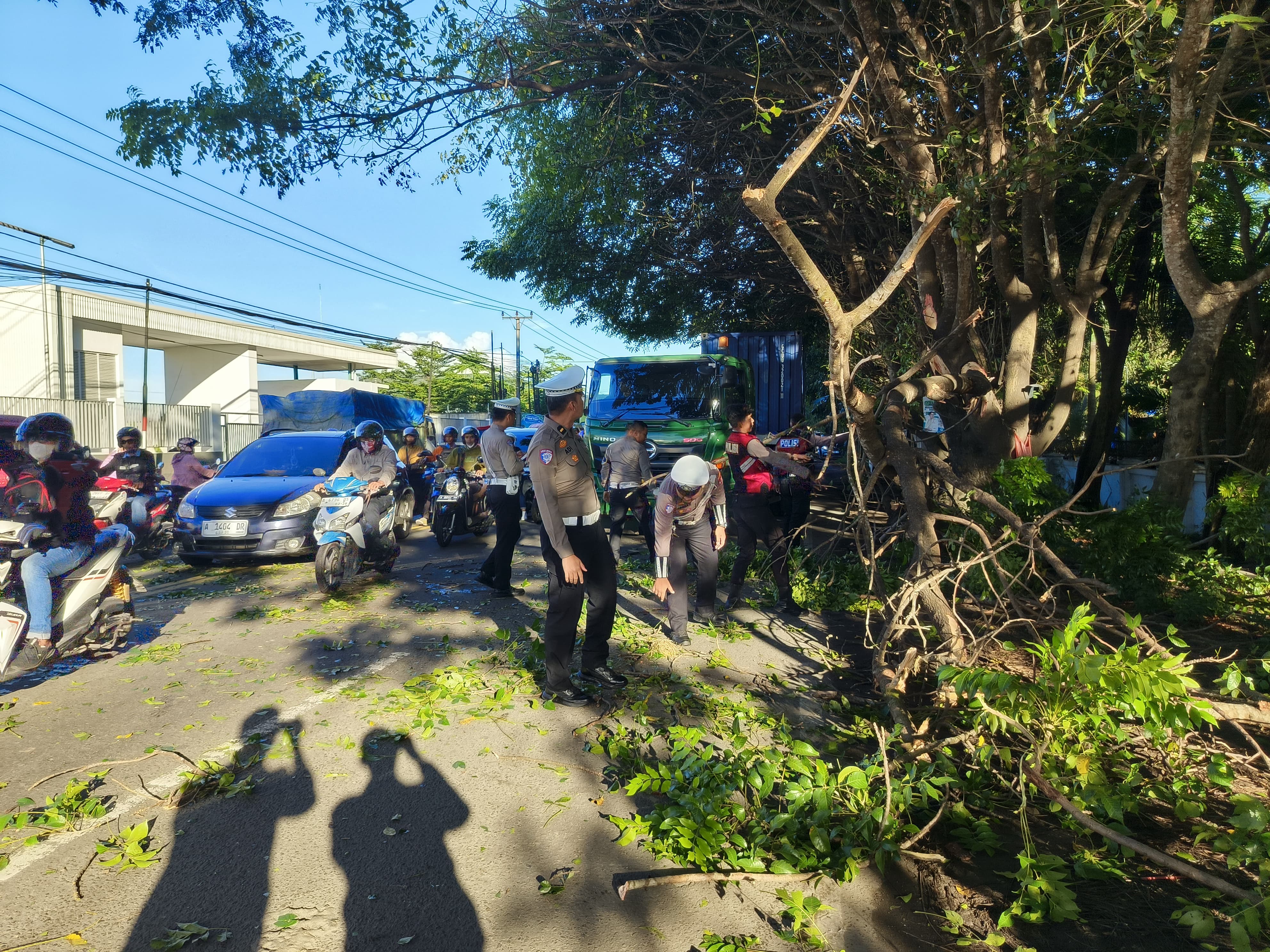 Personil Satlantas Polres Serang Bersihkan Dahan Pohon Yang Menutup Jalan