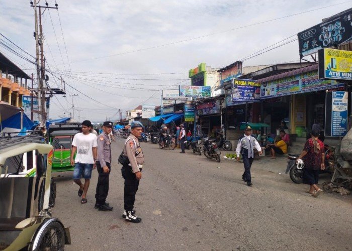 Personel Polsek Babul Makmur Atur Lalu Lintas Untuk Cegah Kemacetan di Pasar Tumpah Pekan Lawe Desky Sabas